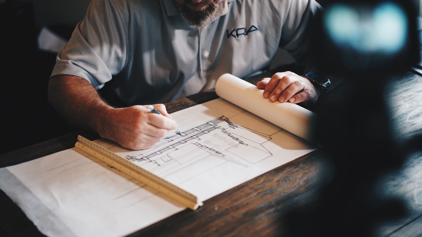 Architect working on blueprints with a pencil and ruler