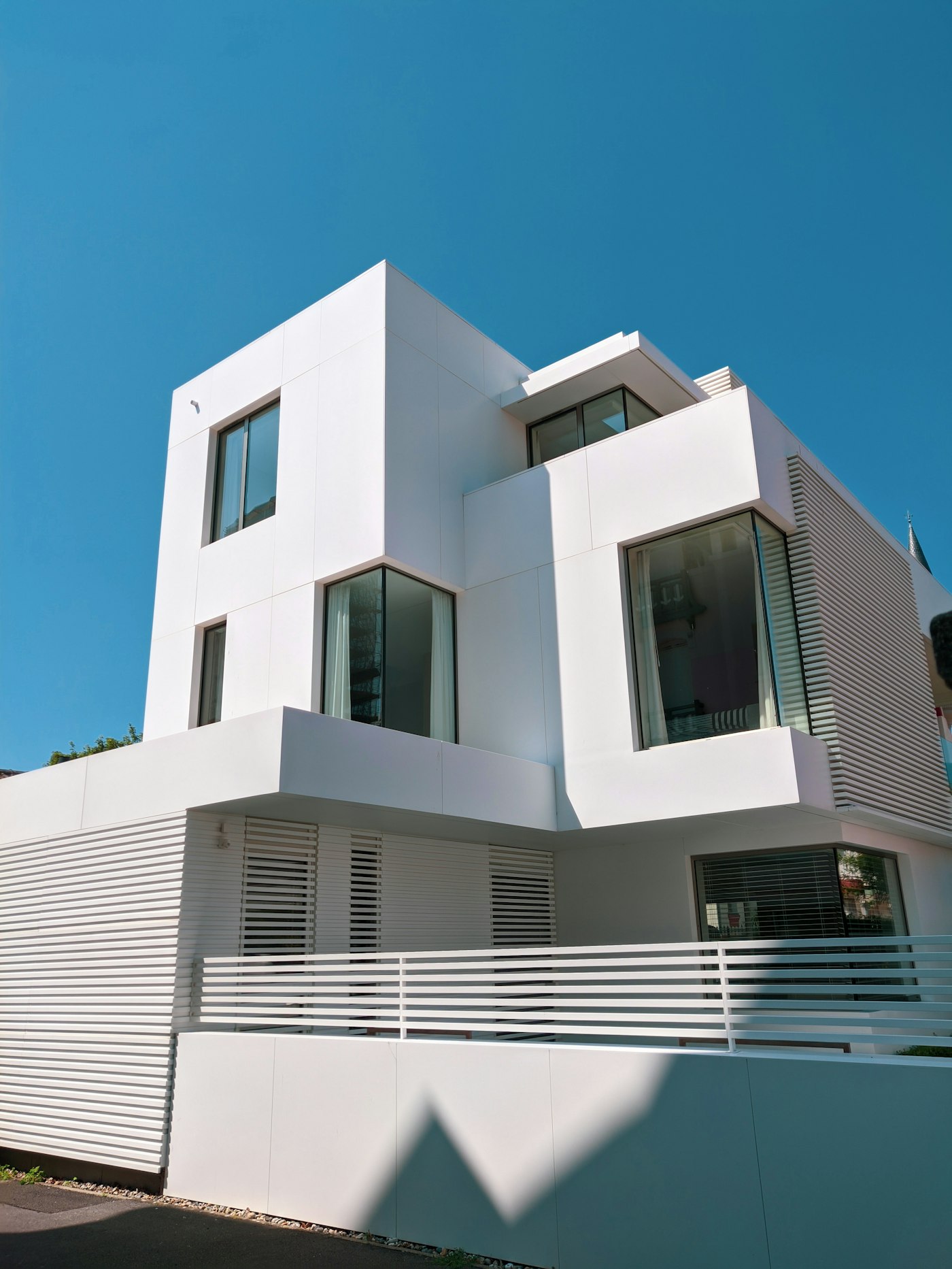 Modern white concrete building under a blue sky